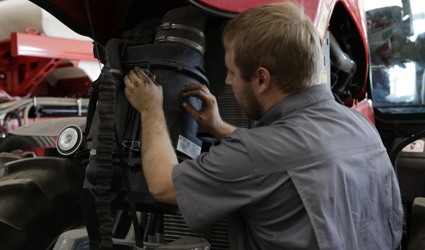 Heavy equipment technician working on a tractor