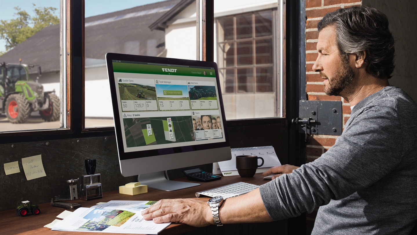 Man looking at precision ag content on a computer in an office